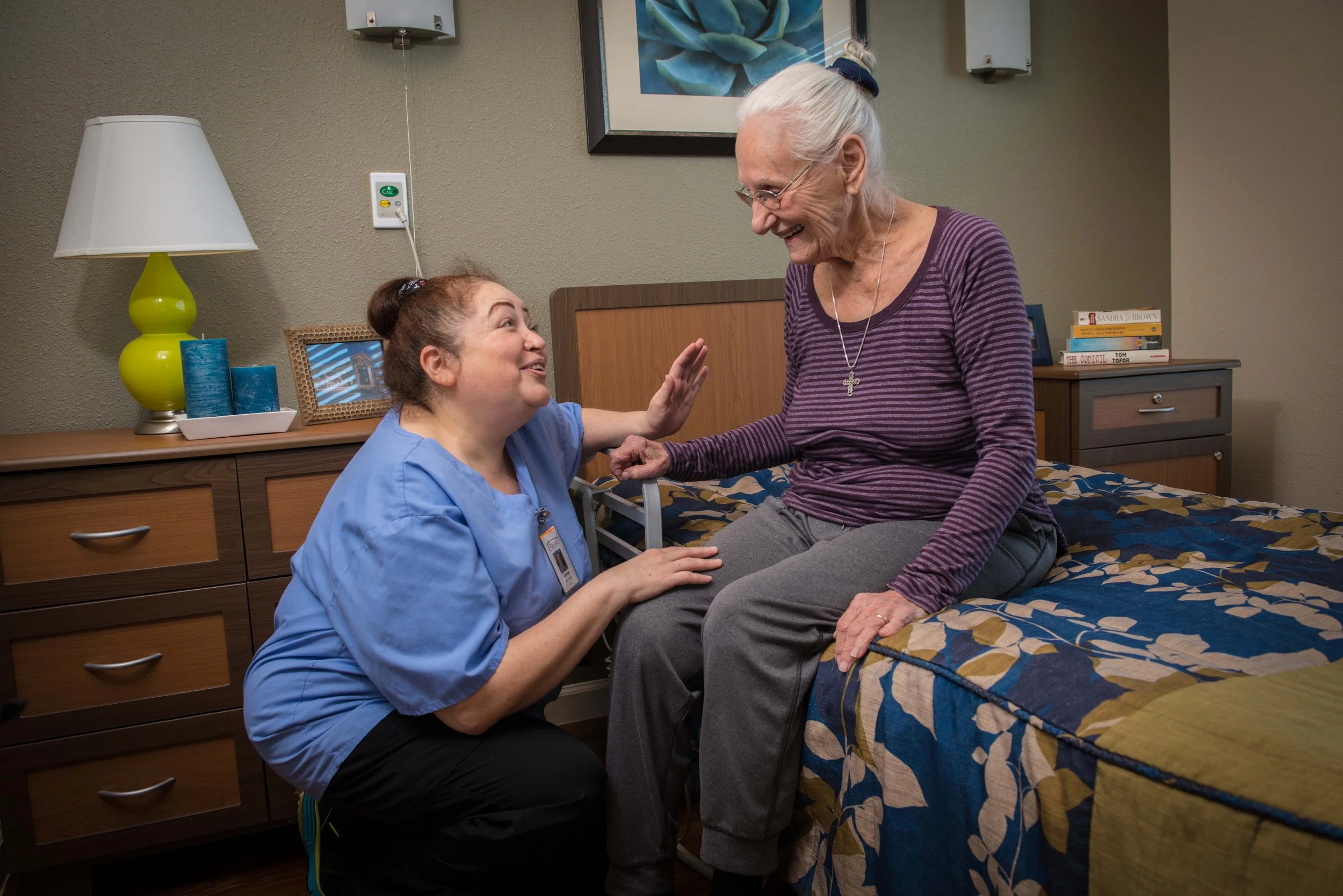 A caregiver interacting with a resident in a cozy room