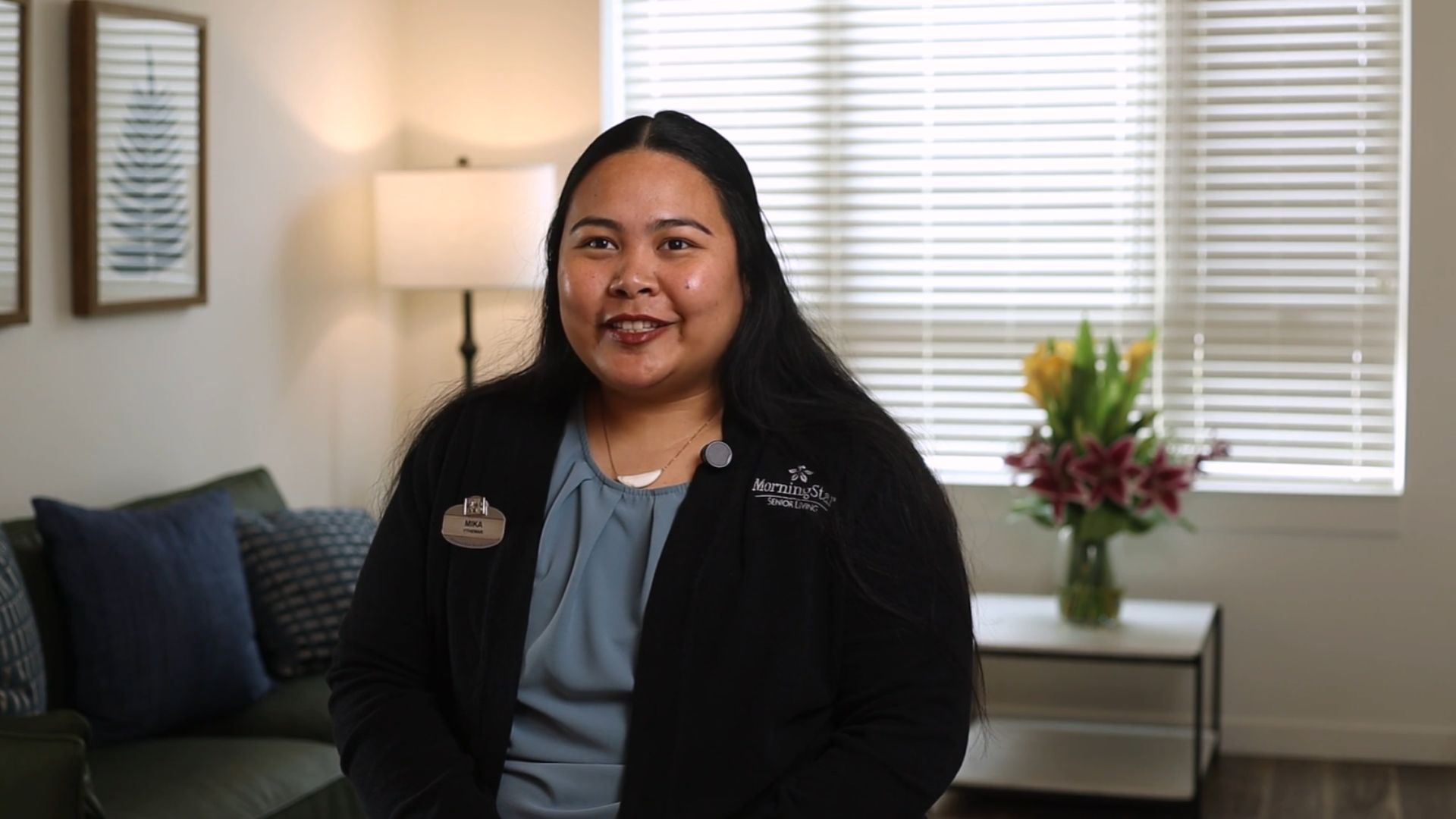 Staff member smiling in a well-lit common area