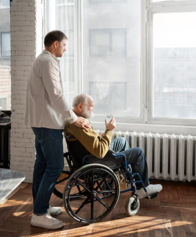Caregiver assisting a resident in a wheelchair by a window