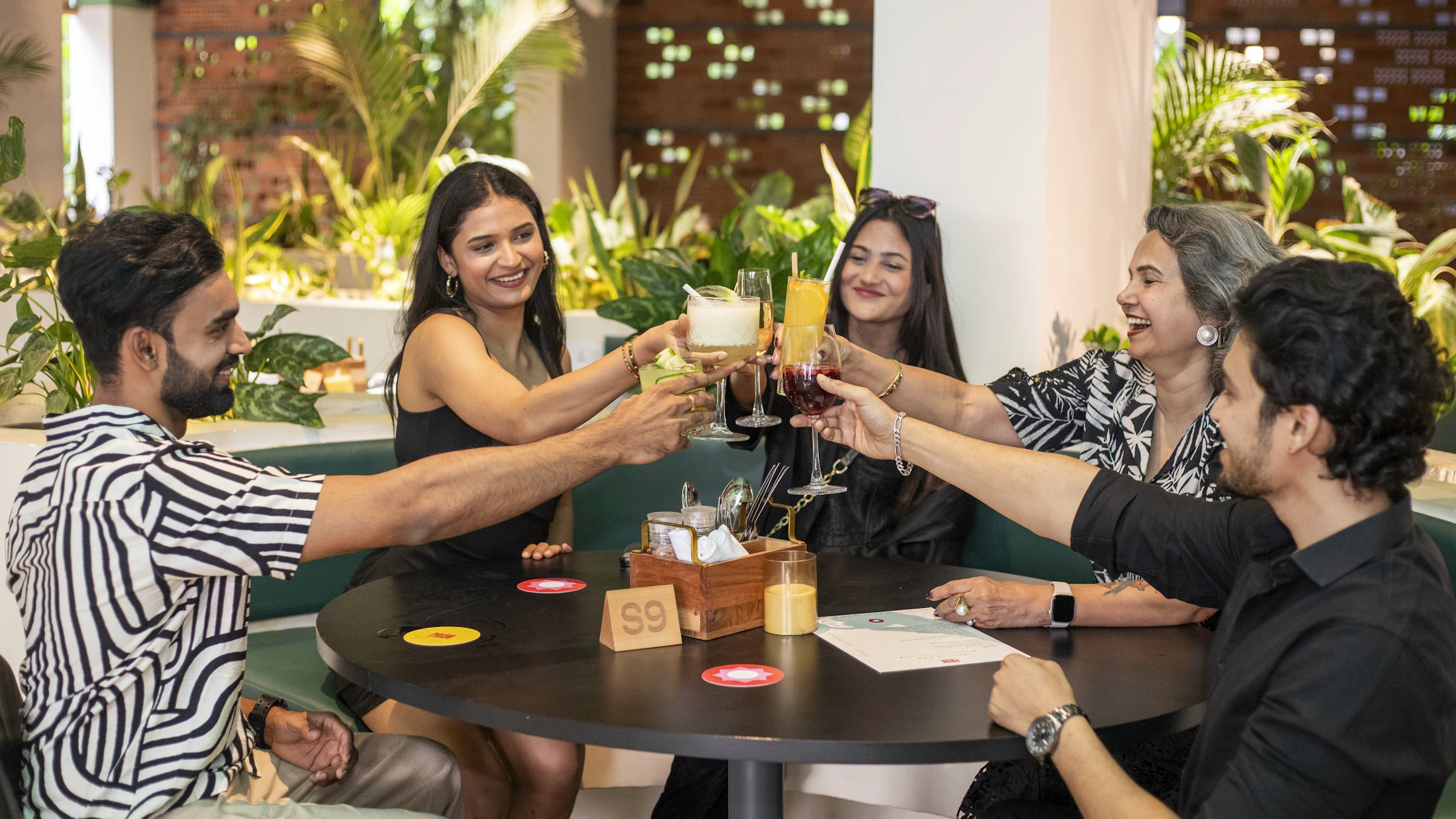 Residents and staff toasting with drinks in a dining area