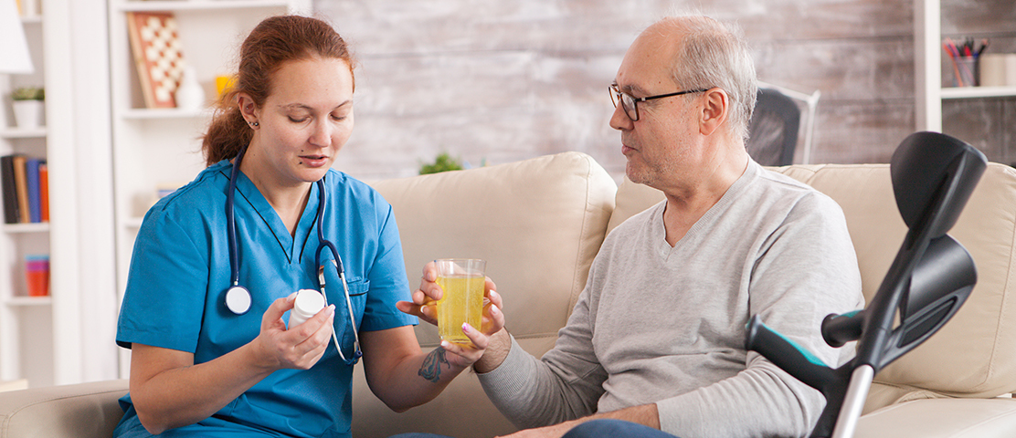 Caregiver assisting a resident in a comfortable living area