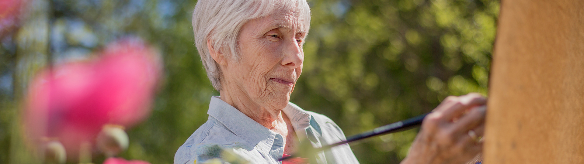 Senior woman painting outdoors in a garden