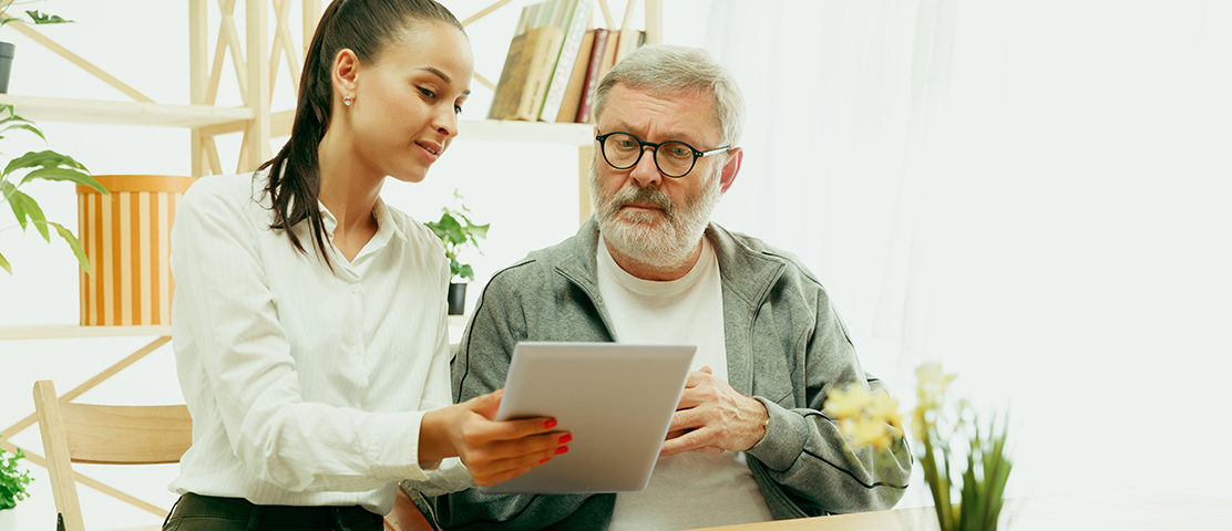 Caregiver assisting a resident with a tablet