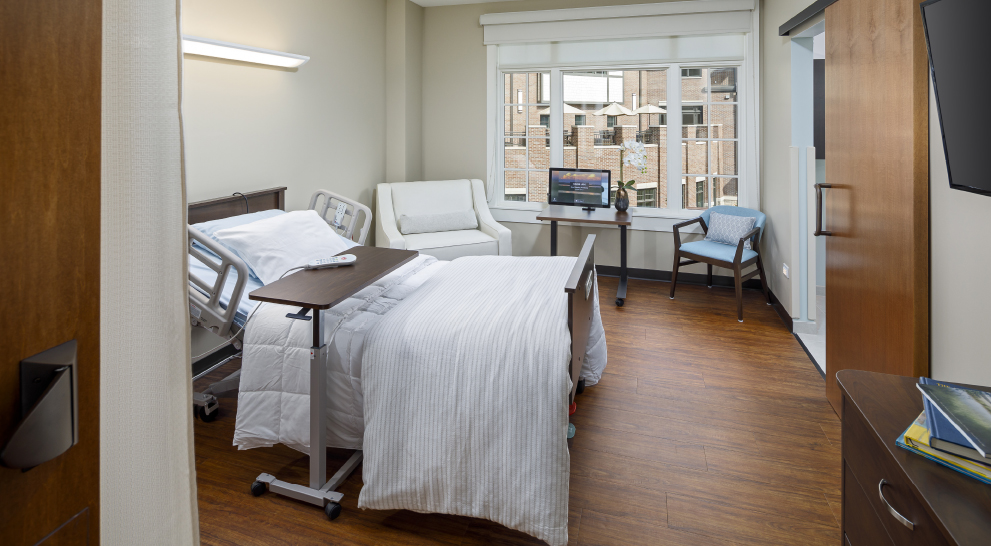 Spacious resident room with a hospital bed and seating area