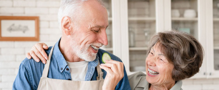 Two senior residents enjoying food preparation together