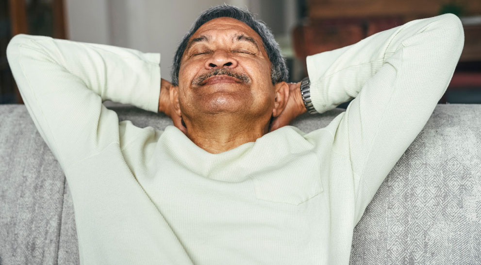 Senior man relaxing on a couch with eyes closed