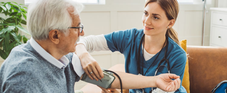 A nurse taking a blood pressure of an elderly man