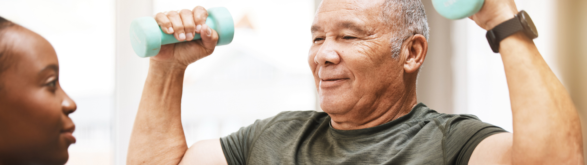 Senior resident exercising with weights in a facility interior