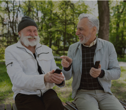 Two elderly men laughing and enjoying outdoor time together