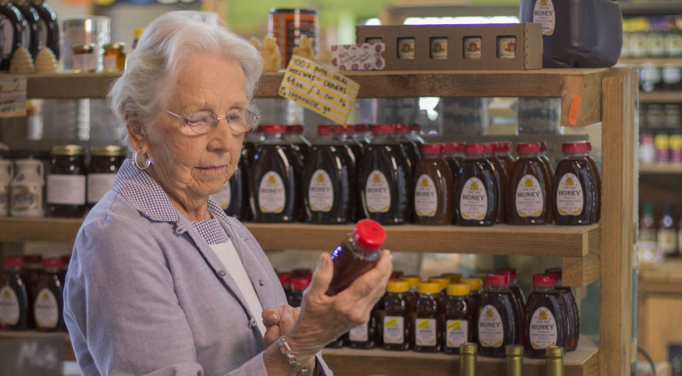 Resident examining a jar of honey in a shop