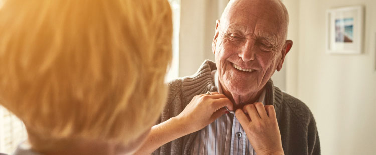A caregiver and resident interacting in a warm indoor setting