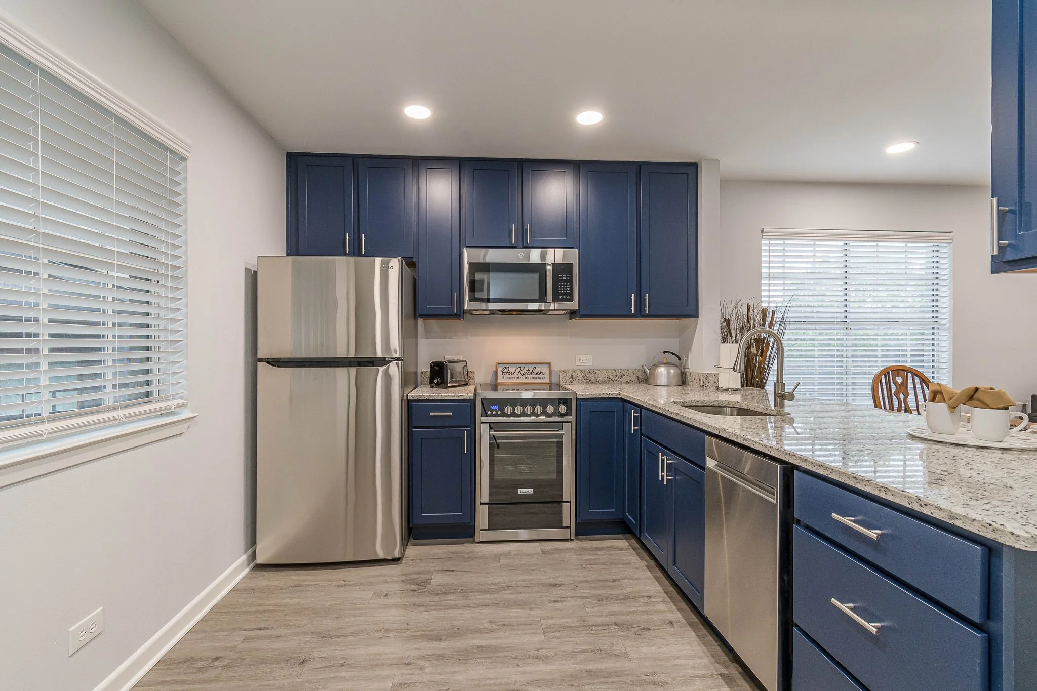 Modern kitchen interior with blue cabinetry and stainless steel appliances