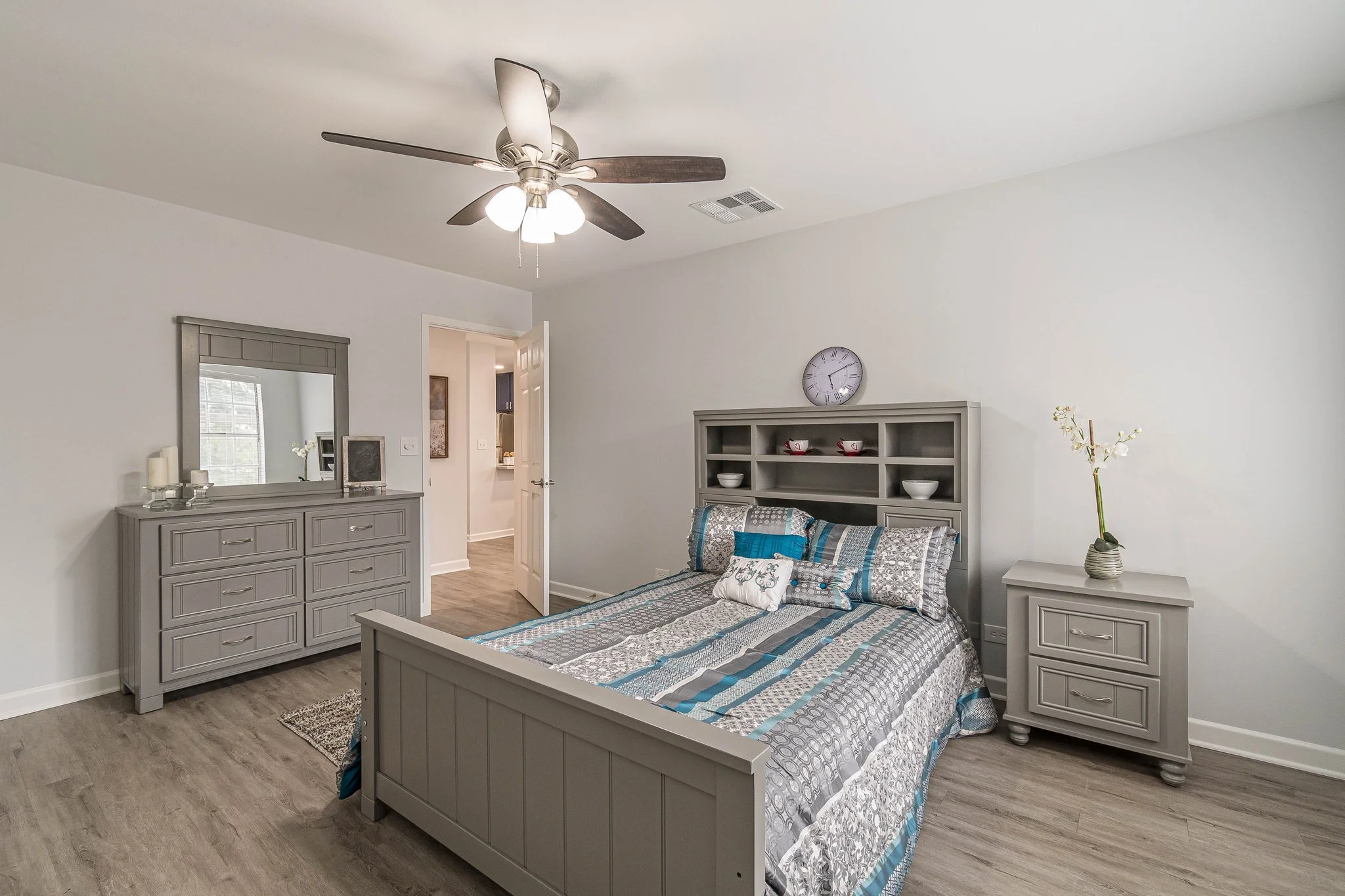 A well-furnished private resident room with a bed and dresser