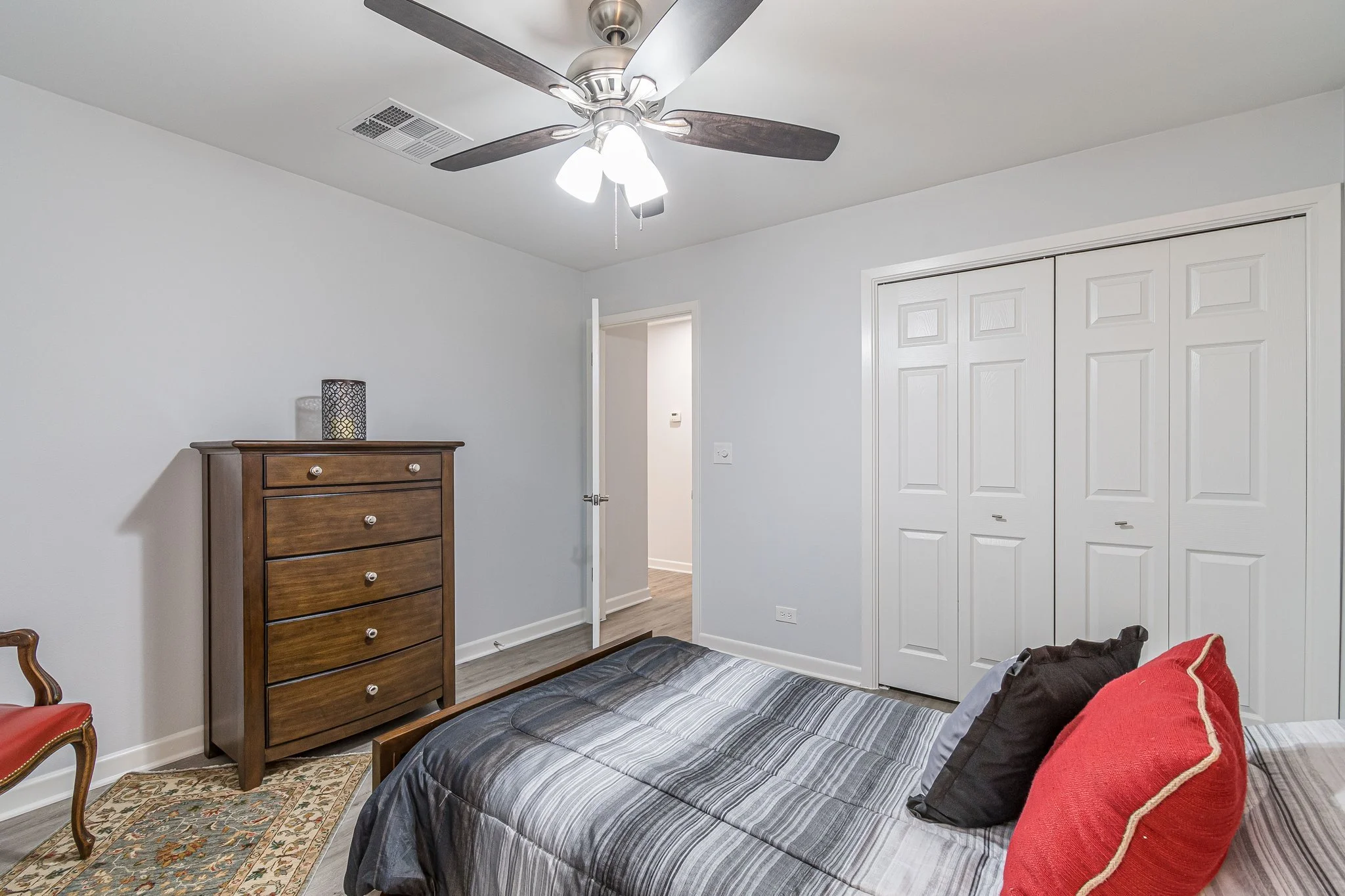 Cozy bedroom with a dresser and decorated bed