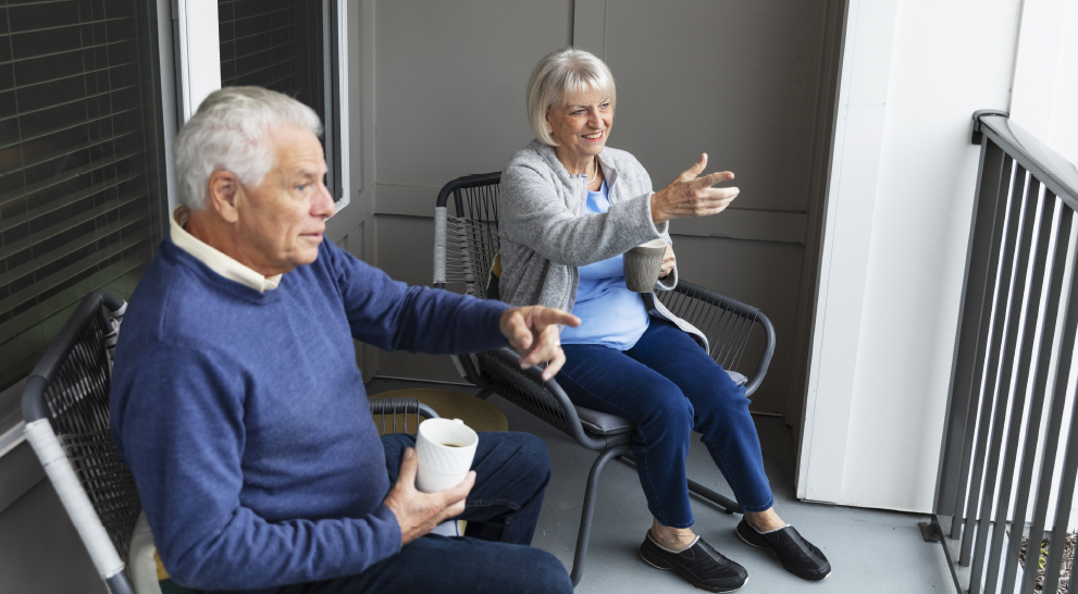 Two residents enjoying coffee on a balcony