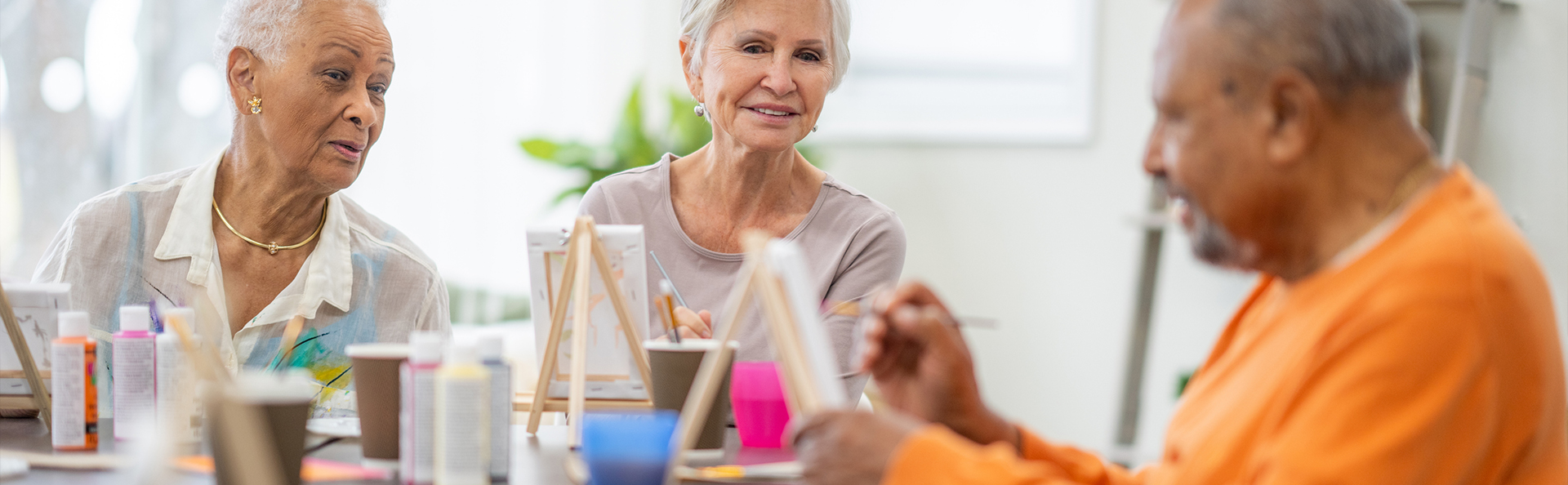 Residents engaged in a painting activity in a bright room
