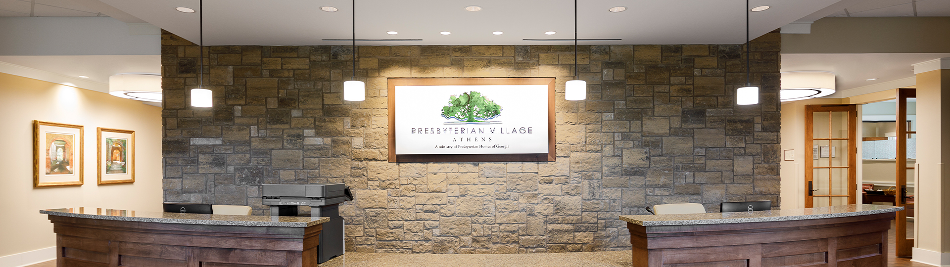 Welcoming reception area with stone wall and facility logo