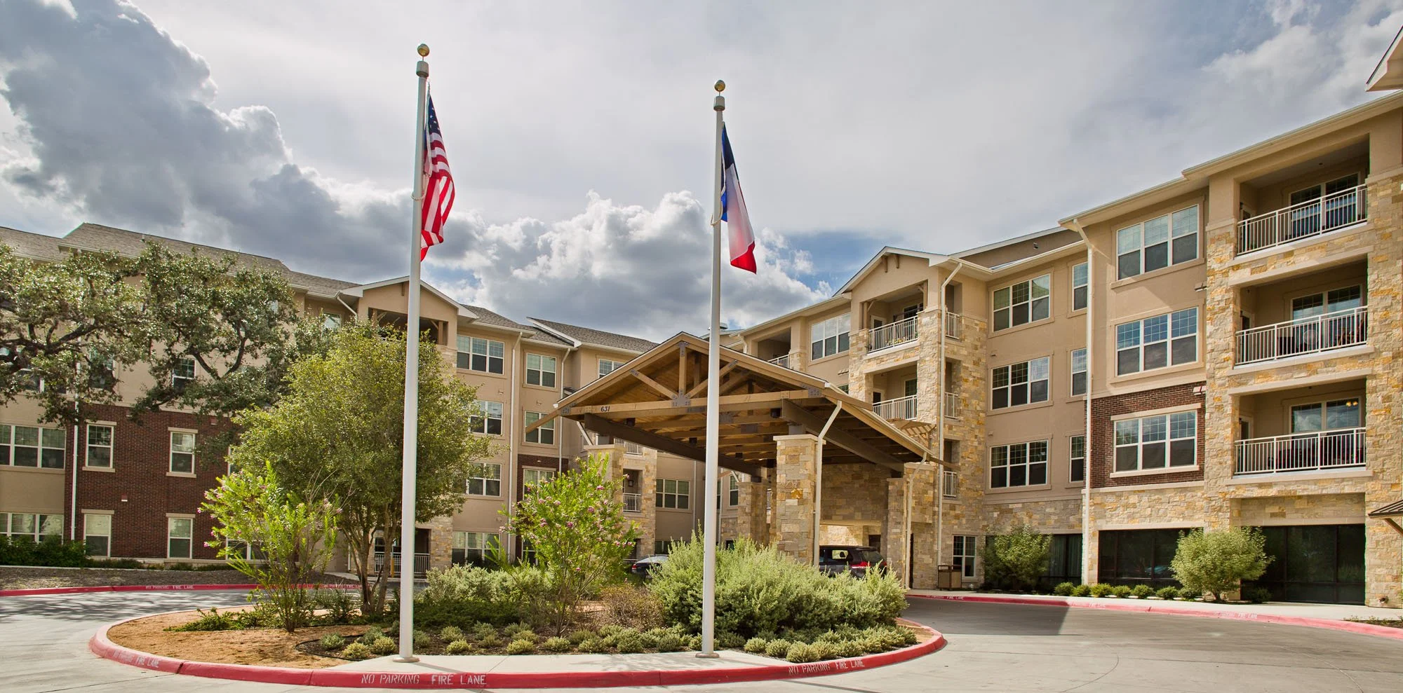 Entrance of a senior living facility with flags