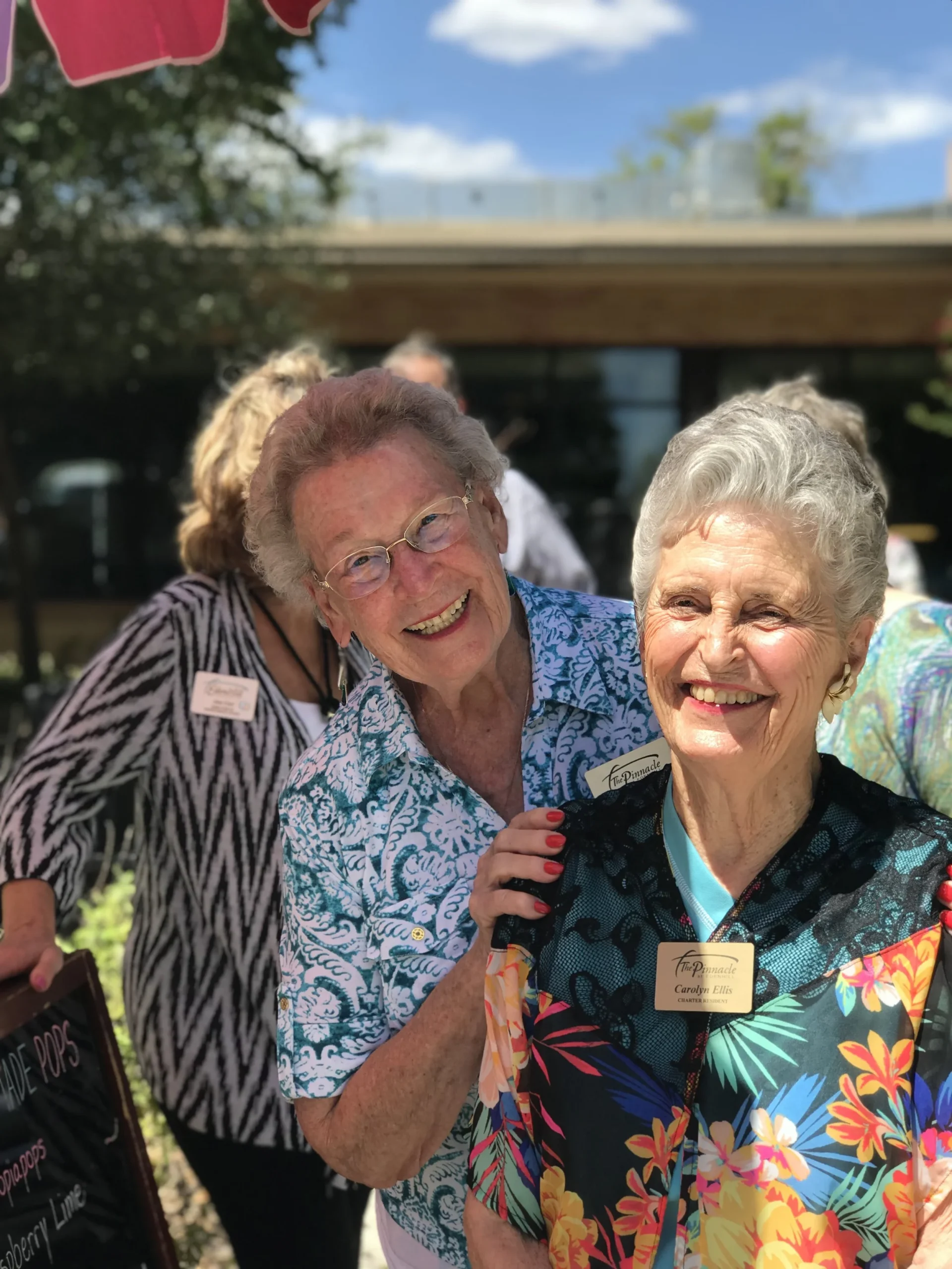 Two smiling residents outdoors at an event