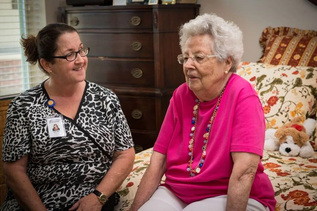 Staff member chatting with a resident in a cozy room