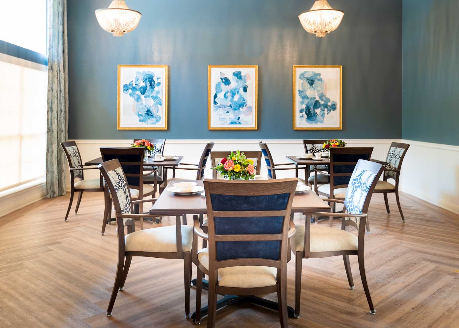 Elegant dining room with tables and floral arrangements.