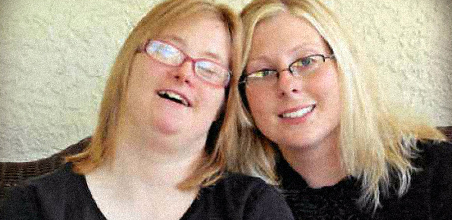 Two women smiling together, showing friendship.