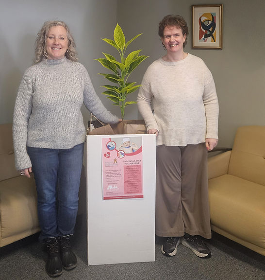 Two staff members beside a plant display.