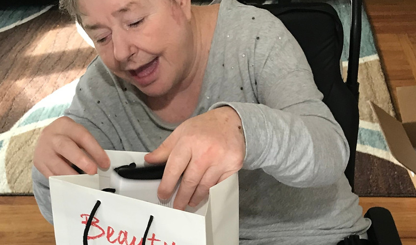 Resident excitedly opening a gift bag indoors.