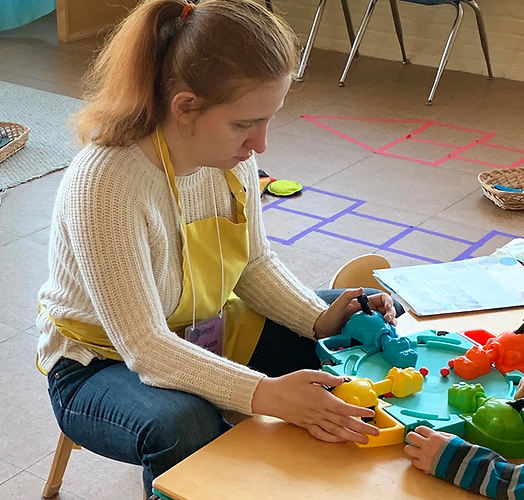 Staff member engaging with a resident in a playful activity.
