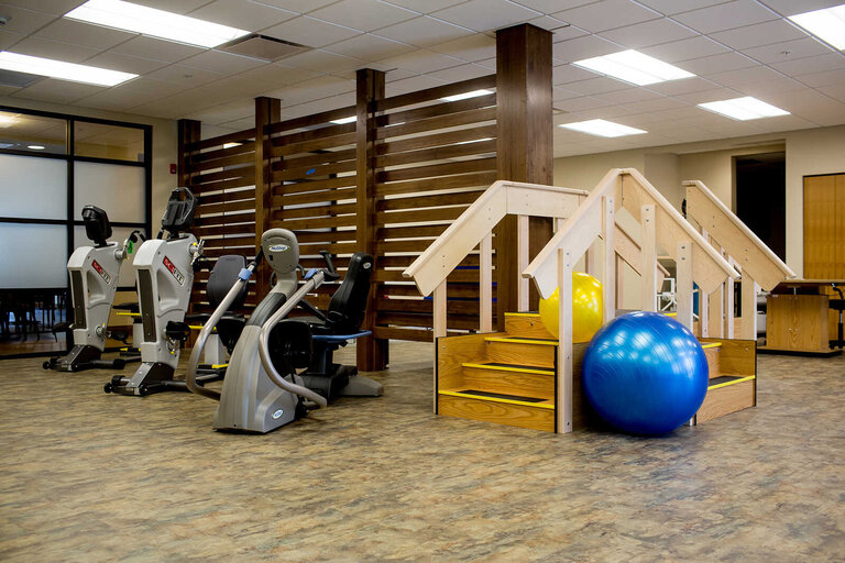 Fitness equipment and therapy space in a senior living facility.