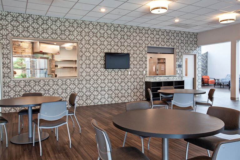 Modern dining area with patterned wall and tables