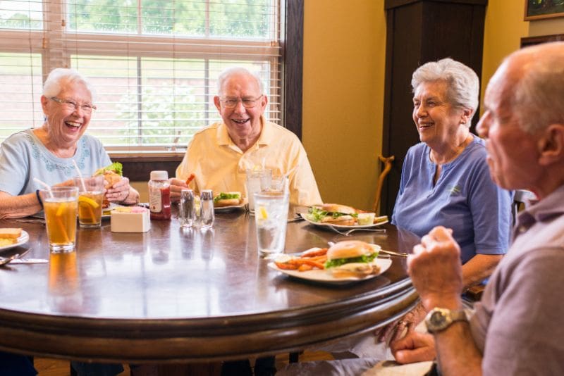 Seniors enjoying a meal together in a dining area.