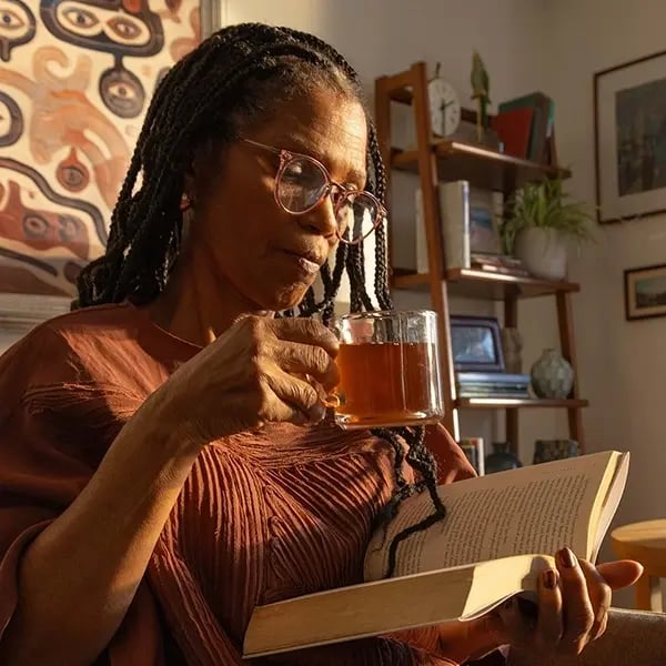 Resident enjoying a book and tea indoors