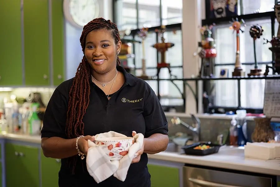 Staff member holding a bowl in the kitchen.