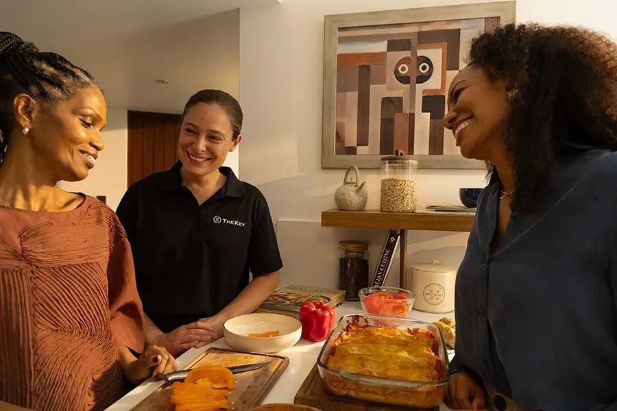 Three people enjoying cooking together in a kitchen