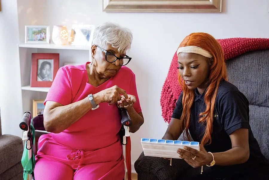 Care staff assists resident with medication management.