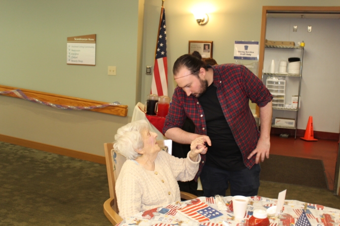 A caregiver interacting with a resident at a table.