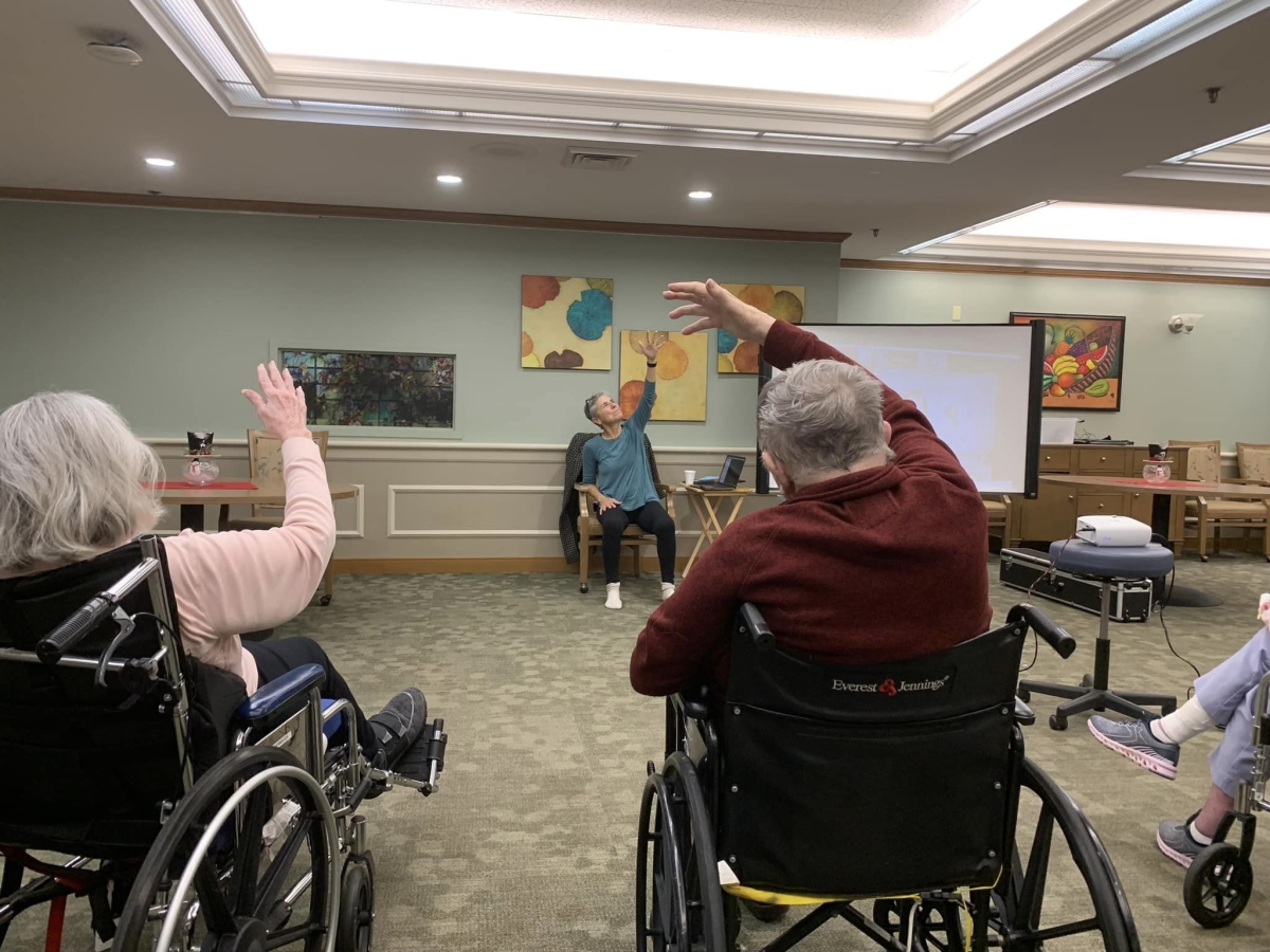 Residents in wheelchairs engaging in a group activity.