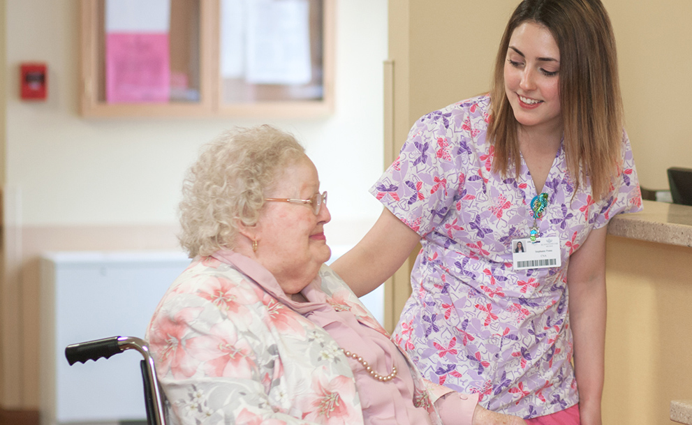 Resident smiling with staff in a nursing home