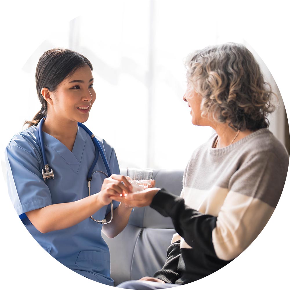 Nurse assisting a senior resident with a drink.