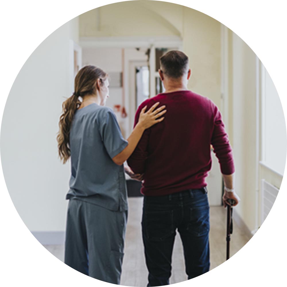 Care staff assisting a resident in a hallway