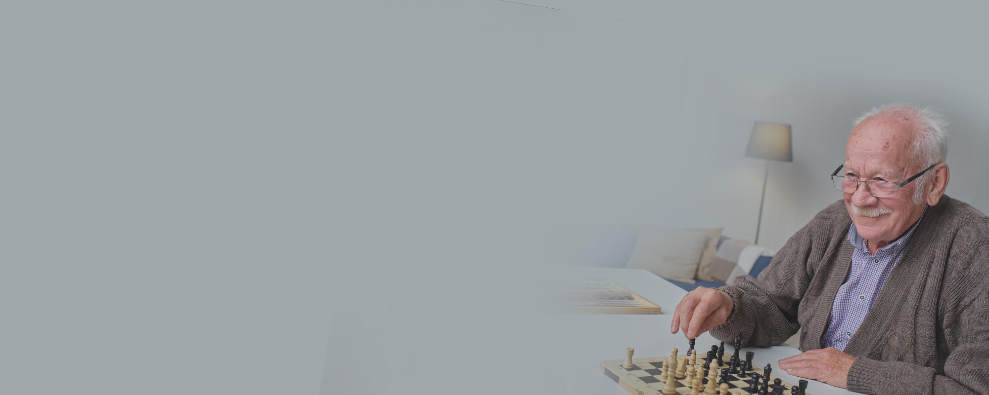 Senior man playing chess in a cozy interior
