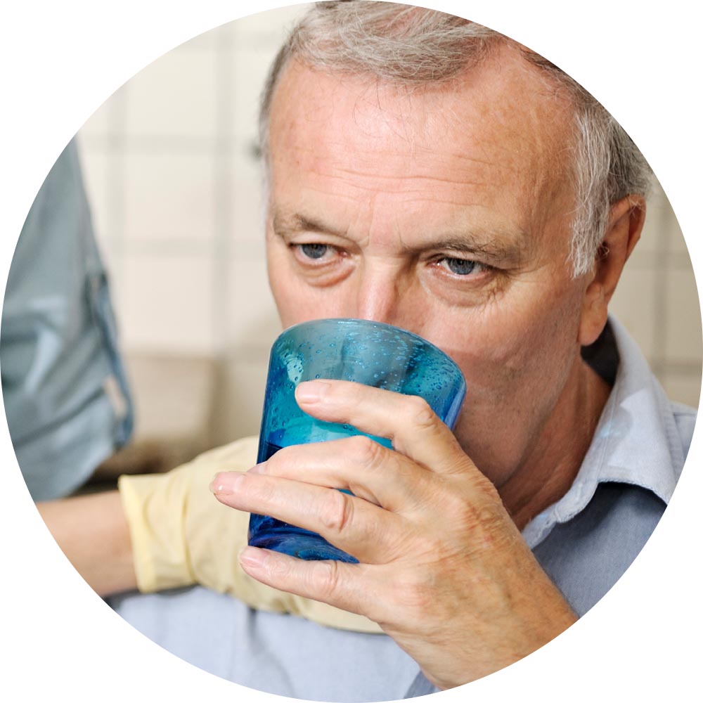 Senior man drinking from a blue glass