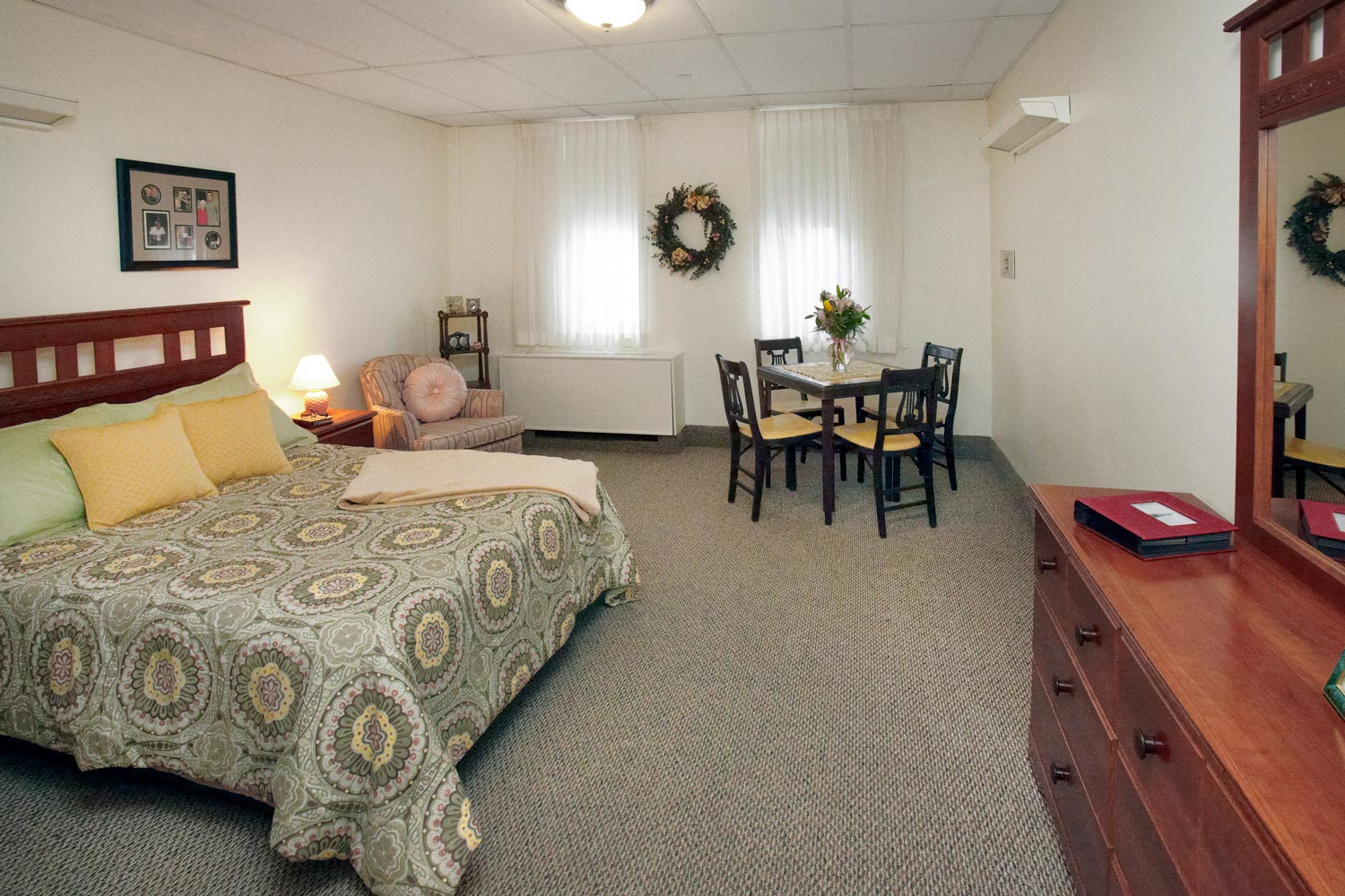 Cozy resident room with bed and dining area.