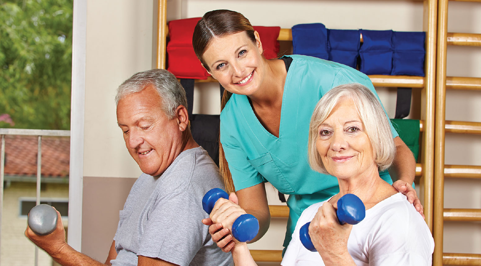 Residents engaged in exercise with staff assistance.