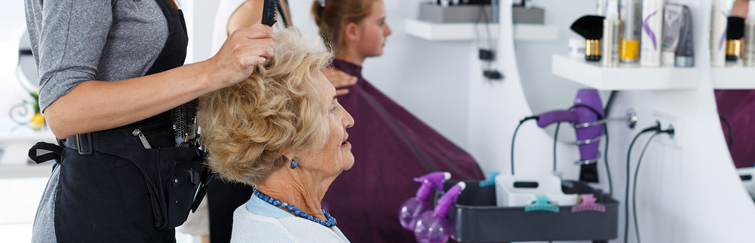 Resident receiving hair styling in a salon.