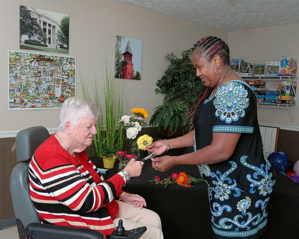 Staff helping resident with floral arrangement