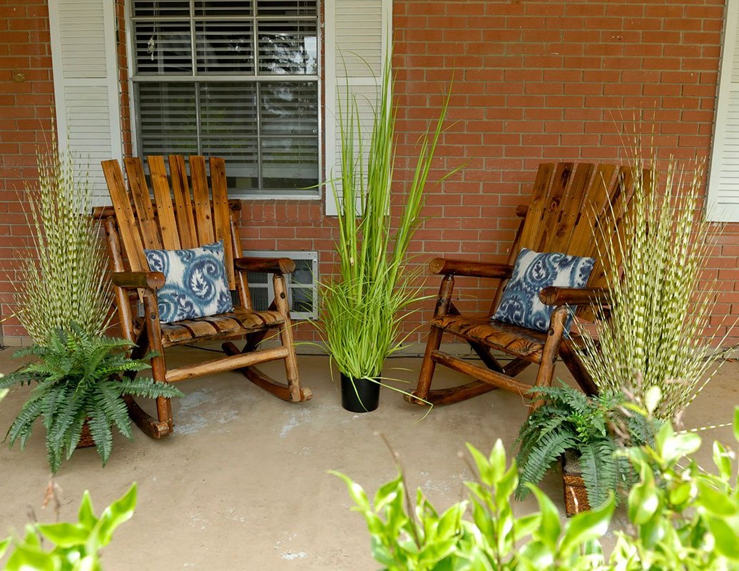 Two wooden rocking chairs on a porch.