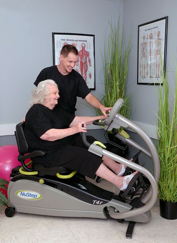 Senior resident exercising with staff guidance.