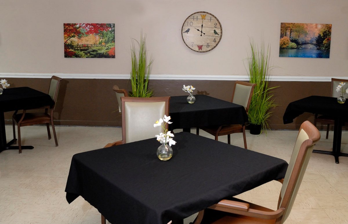 Dining area with tables and decorative plants.